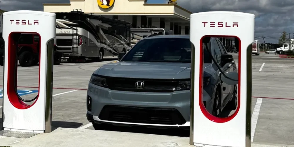 Can Honda Prologue Use Tesla Charger? A Honda Prologue is shown charging at a Tesla Supercharger equipped with Magic Dock for non-Tesla EV compatibility.